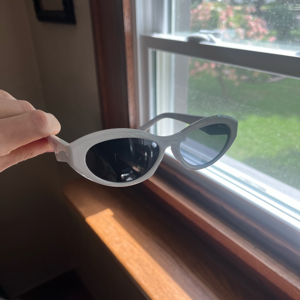 Prada White cate eye sunglasses with silver accents on the side charcoal lens